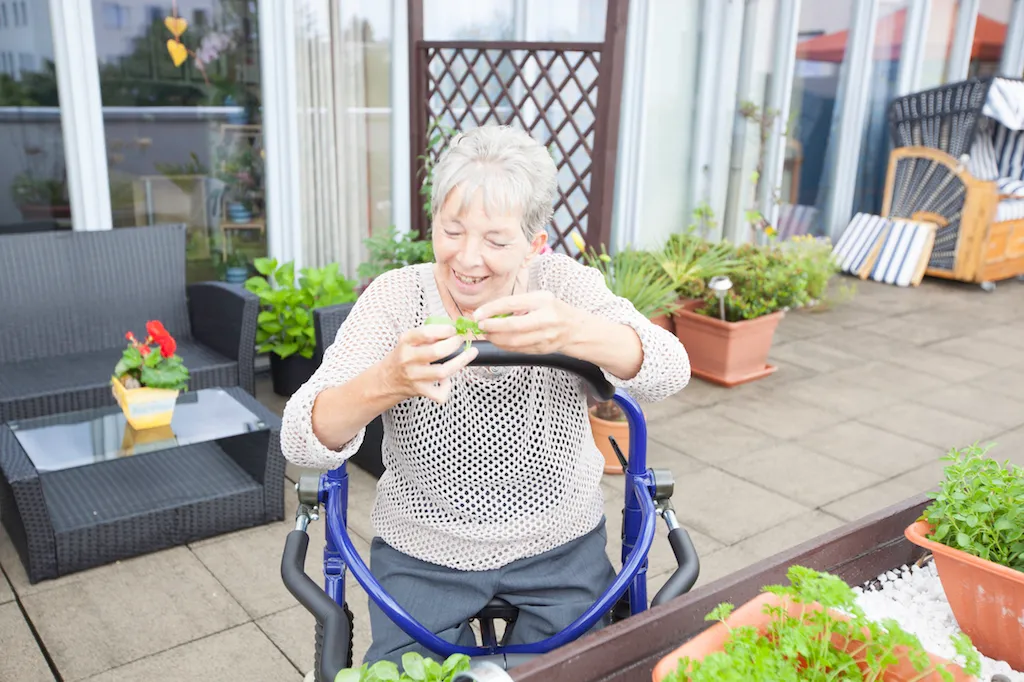 Bewohnerin bei einer Aktivität auf der bepflanzten Terrasse